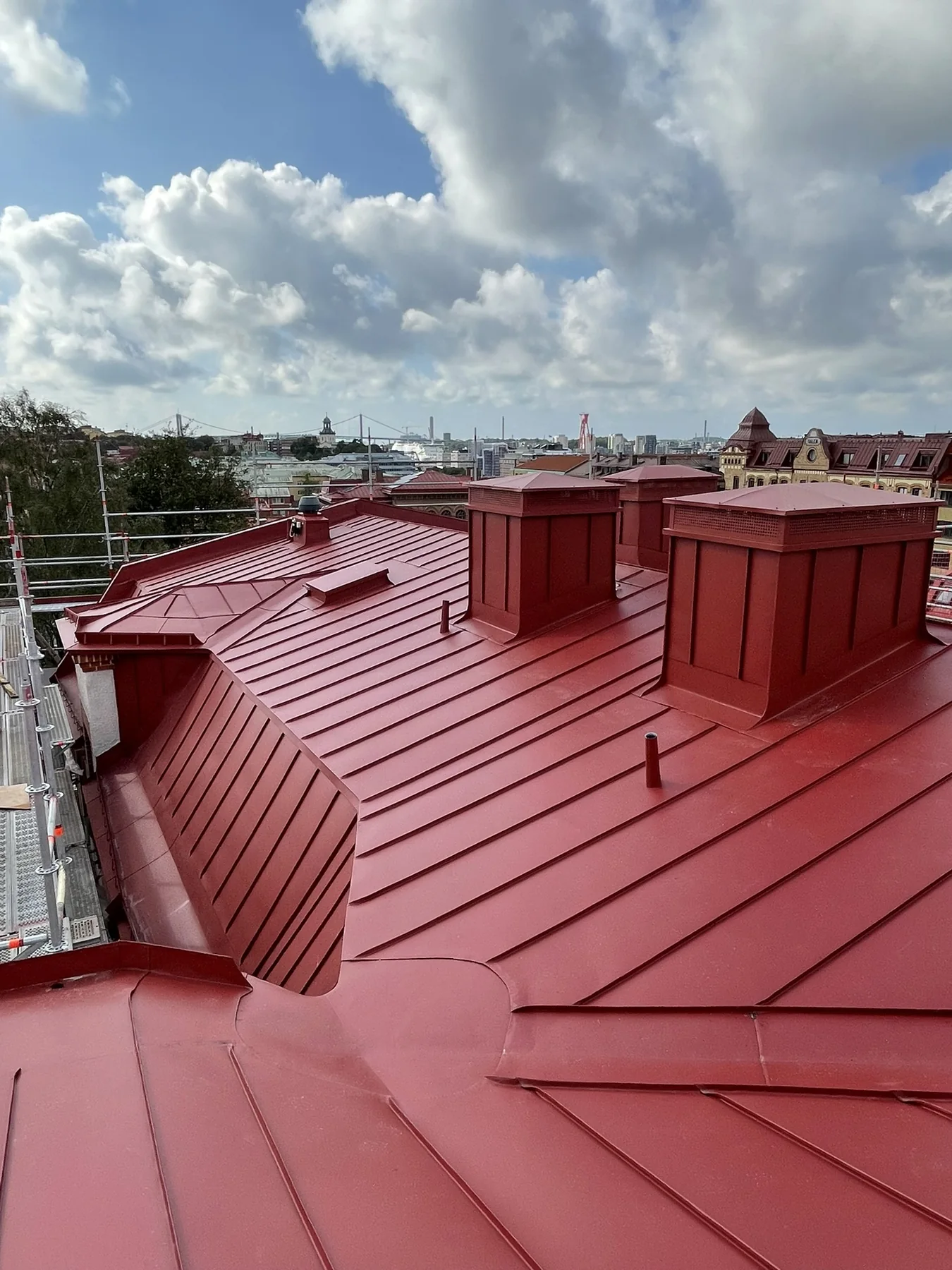 Rött bandtäckt plåttak med flera takfall